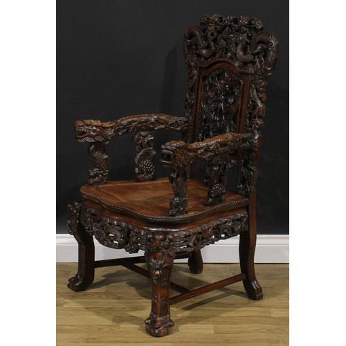 1863 - A pair of Chinese hongmu armchairs, carved throughout with dragons and stylised clouds, serpentine s... 