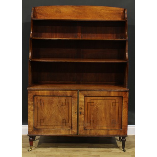 2364 - A Regency mahogany waterfall bookcase, open shelves above a pair of panel doors, turned feet, brass ... 