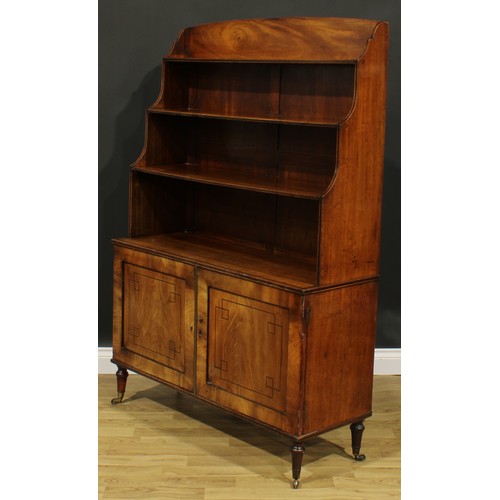 2364 - A Regency mahogany waterfall bookcase, open shelves above a pair of panel doors, turned feet, brass ... 