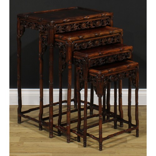 2372 - A set of Chinese hardwood quartetto tables, each apron pierced and carved with bats and shòu, the fr... 