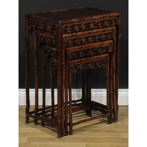 2372 - A set of Chinese hardwood quartetto tables, each apron pierced and carved with bats and shòu, the fr... 