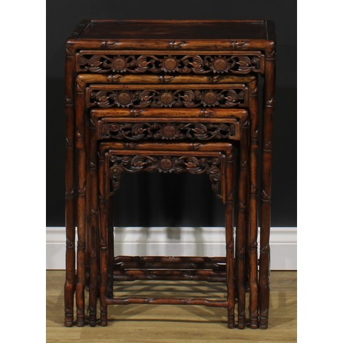 2372 - A set of Chinese hardwood quartetto tables, each apron pierced and carved with bats and shòu, the fr... 