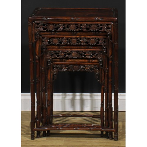 2372 - A set of Chinese hardwood quartetto tables, each apron pierced and carved with bats and shòu, the fr... 