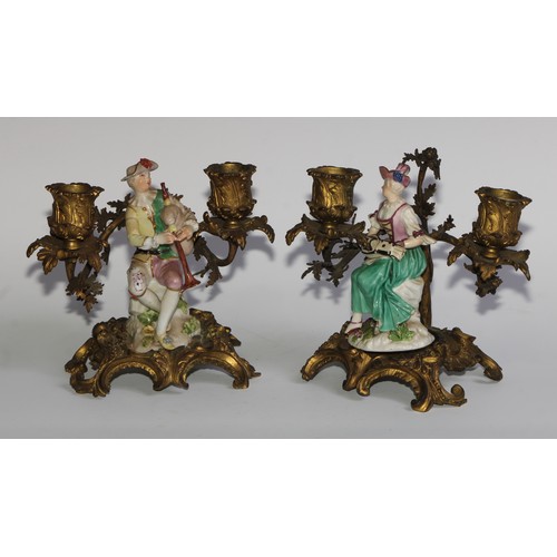 2087 - A pair of German porcelain figures, of musicians, mounted upon a pair of ormolu two-light candelabra... 