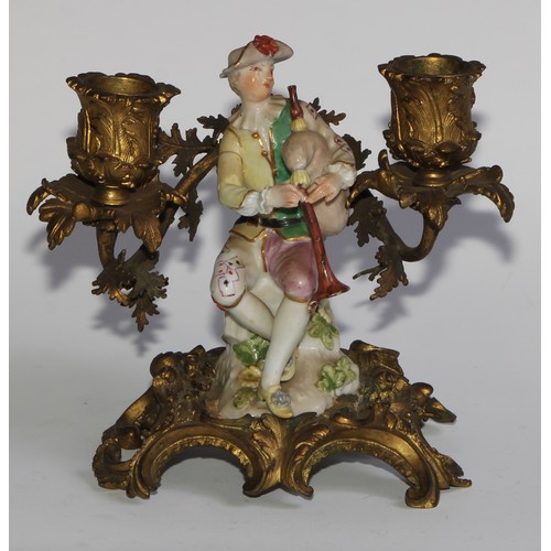 2087 - A pair of German porcelain figures, of musicians, mounted upon a pair of ormolu two-light candelabra... 