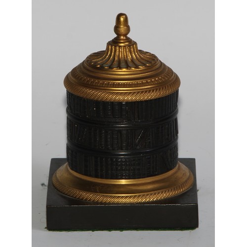 2547 - A Regency dark patinated and gilt bronze cylindrical library inkwell, cast as a rotunda bookcase, ac... 