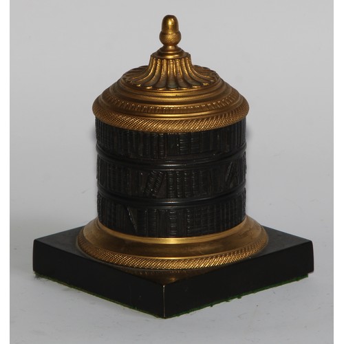 2547 - A Regency dark patinated and gilt bronze cylindrical library inkwell, cast as a rotunda bookcase, ac... 