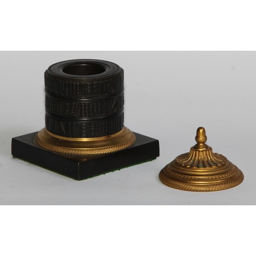 2547 - A Regency dark patinated and gilt bronze cylindrical library inkwell, cast as a rotunda bookcase, ac... 