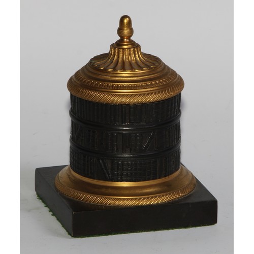 2547 - A Regency dark patinated and gilt bronze cylindrical library inkwell, cast as a rotunda bookcase, ac... 