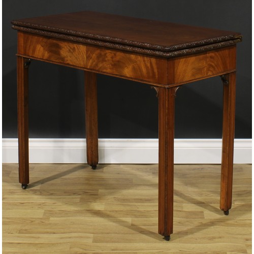 2175 - A George III mahogany tea table, hinged top with carved edge above a flame-veneered frieze, moulded ... 