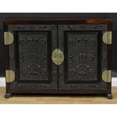 2030 - A Chinese hardwood side cabinet, rectangular top above a pair of panel doors carved and applied with... 