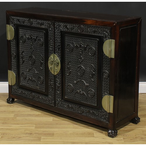 2030 - A Chinese hardwood side cabinet, rectangular top above a pair of panel doors carved and applied with... 