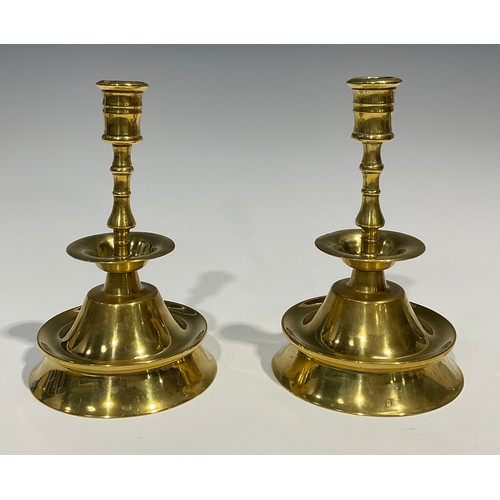 A pair of 19th century brass candlesticks, possibly Spanish, broad drip  pan, trumpet shaped base, 20