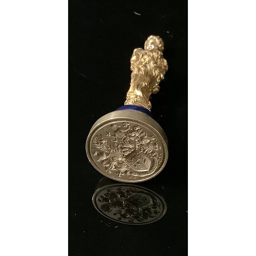 2242 - A German silver gilt figural desk seal, cast as a girl, possibly allegorical of spring standing hold... 