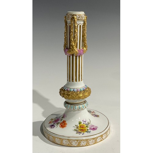 297 - A near pair of Continental porcelain candlesticks, the fluted columns moulded with swags, beaded and... 