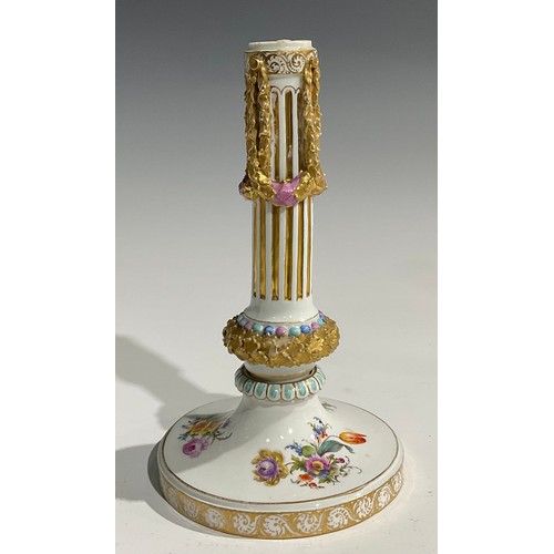 297 - A near pair of Continental porcelain candlesticks, the fluted columns moulded with swags, beaded and... 