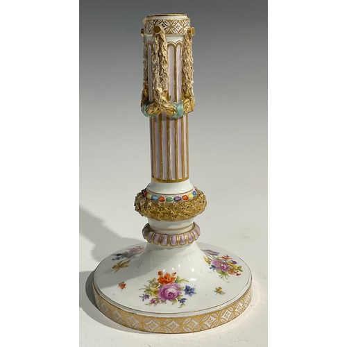 297 - A near pair of Continental porcelain candlesticks, the fluted columns moulded with swags, beaded and... 