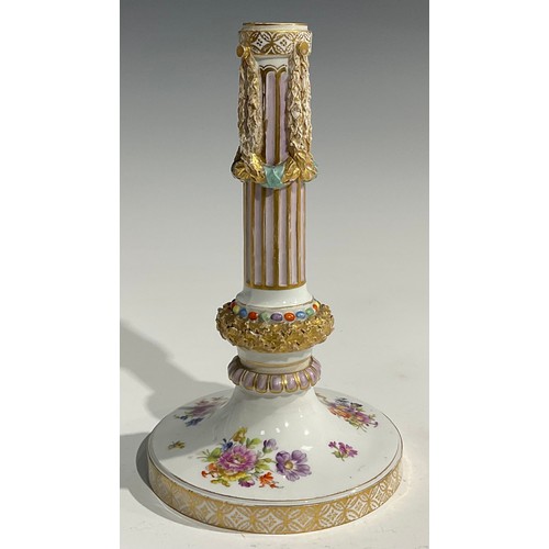 297 - A near pair of Continental porcelain candlesticks, the fluted columns moulded with swags, beaded and... 