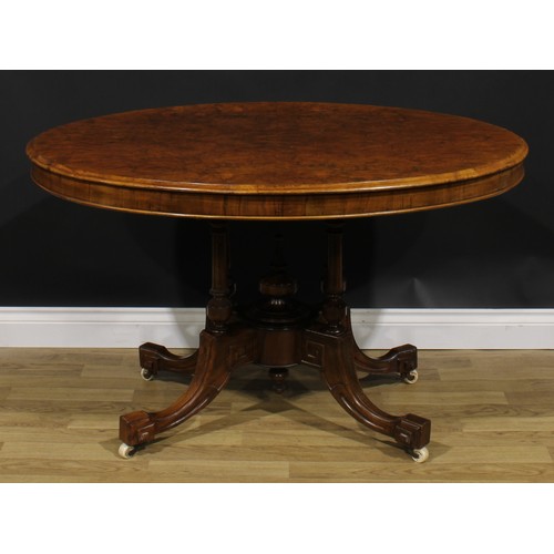 2184 - A Victorian walnut centre table, oval tilting top, turned and fluted columns, sabre legs, ceramic ca... 