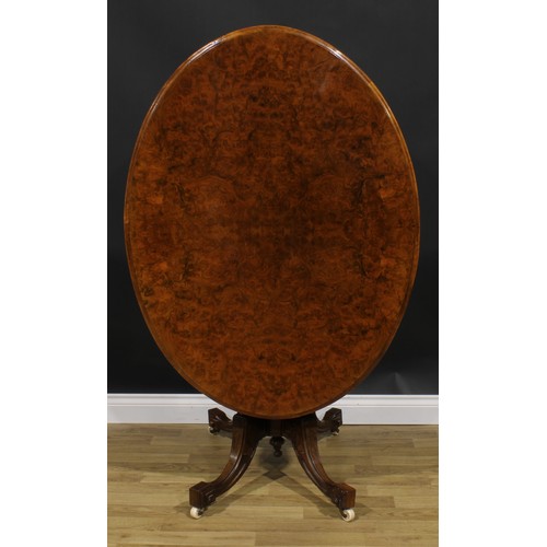 2184 - A Victorian walnut centre table, oval tilting top, turned and fluted columns, sabre legs, ceramic ca... 