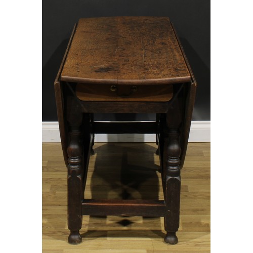 2001 - An 18th century oak gateleg dining table, oval top with fall leaves above a later frieze drawer, tur... 