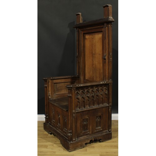 2569 - A substantial Gothic Revival oak throne-form chair, rectangular back, plank seat, carved and applied... 