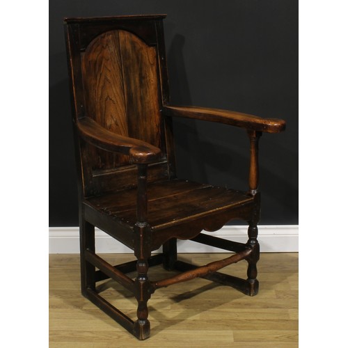 1998 - An 18th century oak and elm panel back armchair, rectangular back, shaped arms, plank seat, shaped a... 