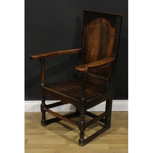 1998 - An 18th century oak and elm panel back armchair, rectangular back, shaped arms, plank seat, shaped a... 