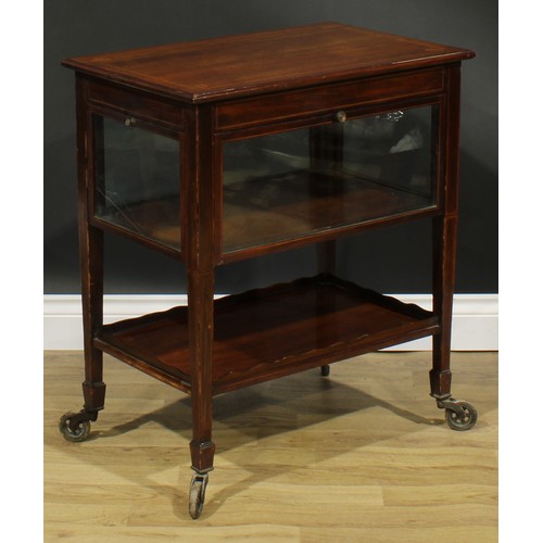 2694 - An Edwardian mahogany butler’s patisserie serving trolley, rectangular top above four glazed fall fr... 