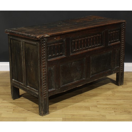 2157 - A late 17th century oak blanket chest, hinged top above a nulled panel front, the stiles carved with... 