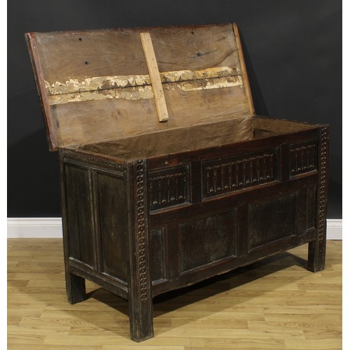 2157 - A late 17th century oak blanket chest, hinged top above a nulled panel front, the stiles carved with... 