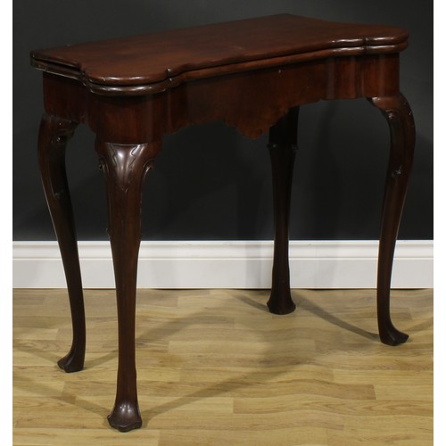 1730 - A George II Irish mahogany card table, hipped rectangular folding top enclosing a baize lined playin... 