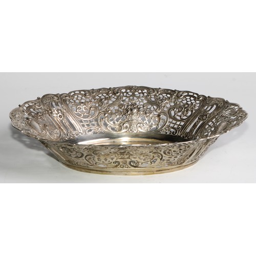 985 - A German silver shaped oval basket, pierced and embossed with flowers, leafy scrolls and vacant cart... 