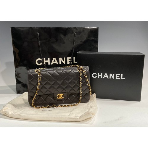 2075 - A Chanel quilted black lambskin leather handbag, double flap with burgundy leather interior, signatu... 