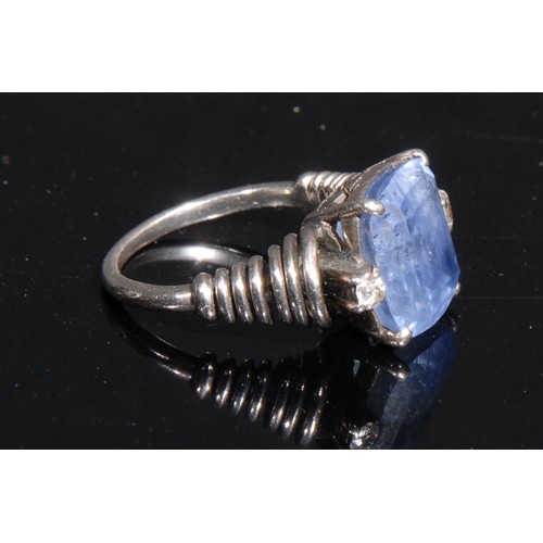 1452 - A unusual sapphire and diamond ring, the large cushion cut sapphire flanked by two brilliant cut dia... 