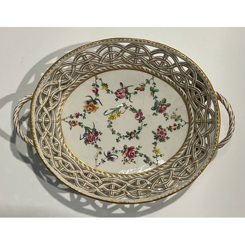 112 - A Bristol reticulated two handled basket, the field painted with a wreath of flowers and floral swag... 