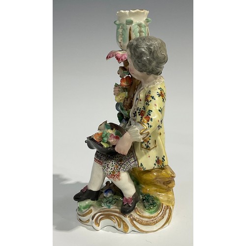 248 - A pair of Derby porcelain figural candlesticks, she seated with an apron of flowers, he holding his ... 