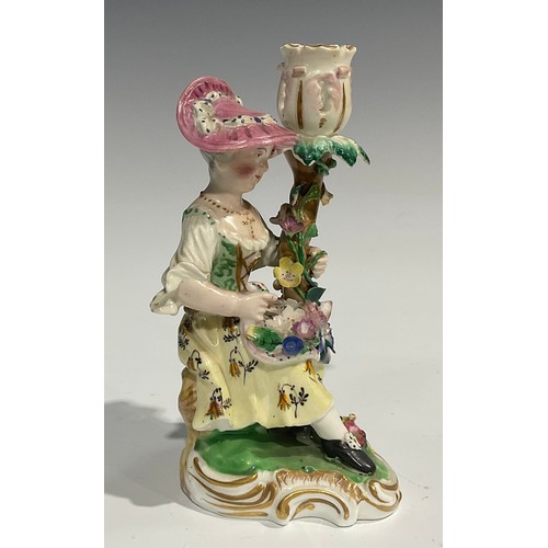 248 - A pair of Derby porcelain figural candlesticks, she seated with an apron of flowers, he holding his ... 