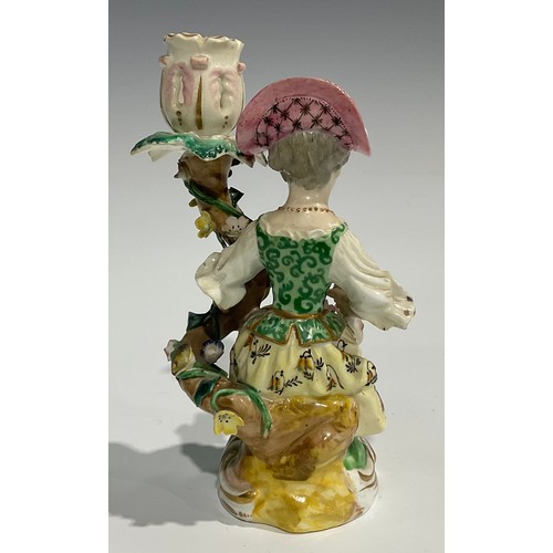 248 - A pair of Derby porcelain figural candlesticks, she seated with an apron of flowers, he holding his ... 