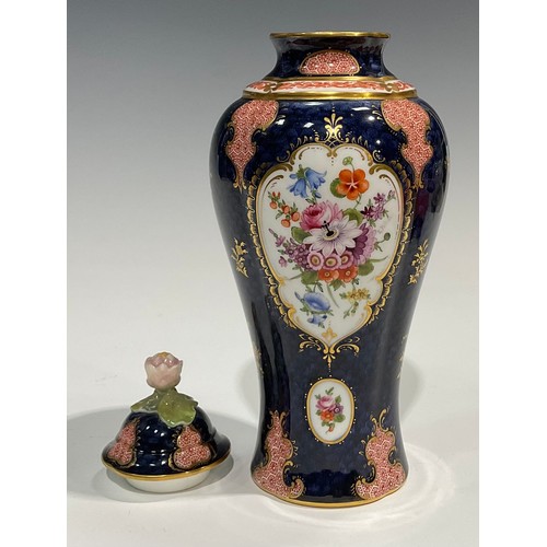 189 - A Royal Worcester baluster vase and cover, by Ernest Phillips, painted with panels of flowers on a b... 