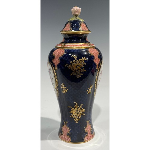 189 - A Royal Worcester baluster vase and cover, by Ernest Phillips, painted with panels of flowers on a b... 