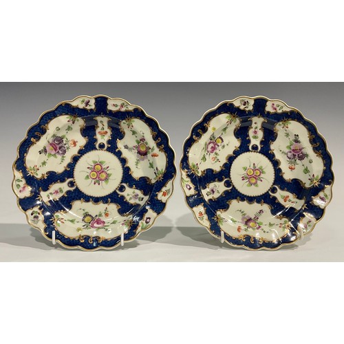 185 - A pair of Worcester shaped circular plates, decorated with alternating fan and vase shaped reserves,... 