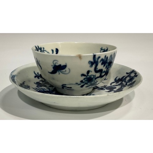 218 - A Worcester Prunus Roots pattern tea bowl and saucer, painted in underglaze blue with scrolling root... 