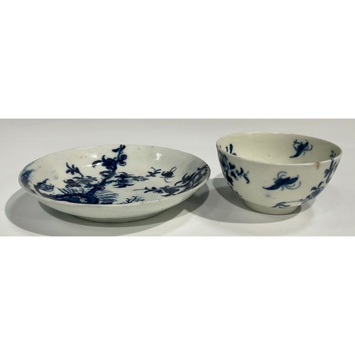 218 - A Worcester Prunus Roots pattern tea bowl and saucer, painted in underglaze blue with scrolling root... 