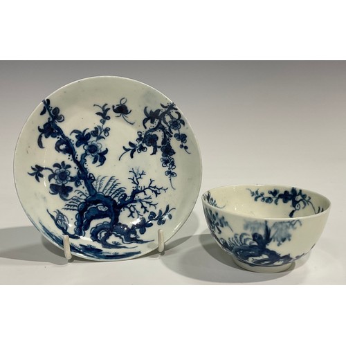 218 - A Worcester Prunus Roots pattern tea bowl and saucer, painted in underglaze blue with scrolling root... 