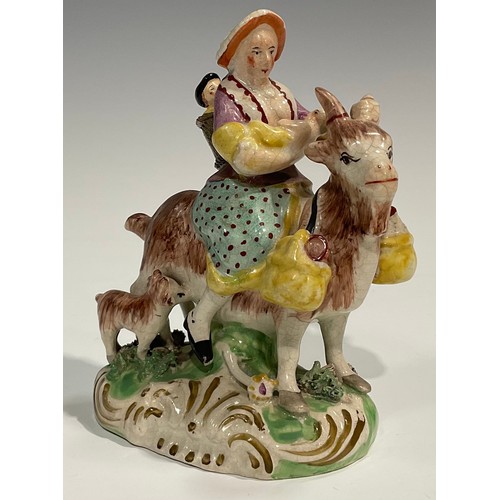 331 - A pair of early 19th century Staffordshire figures, The Welsh Tailor and Wife, both seated astride a... 