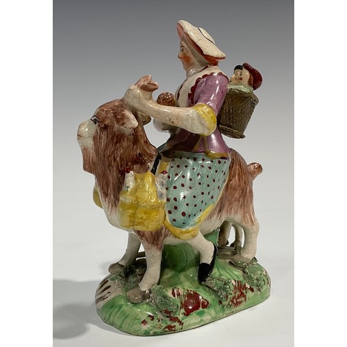 331 - A pair of early 19th century Staffordshire figures, The Welsh Tailor and Wife, both seated astride a... 