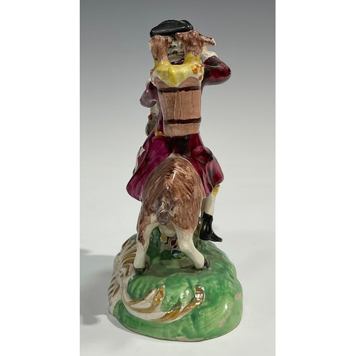 331 - A pair of early 19th century Staffordshire figures, The Welsh Tailor and Wife, both seated astride a... 