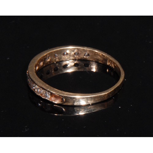 1370 - A diamond half eternity ring, stamped '14K' for 14ct gold, 12 brilliant cut channel set stones, O/P,... 