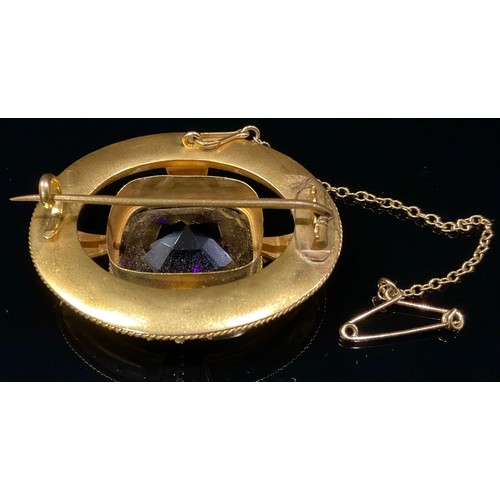 1458 - A Victorian amethyst and gold coloured metal oval brooch in the Etruscan revival manor, the central ... 